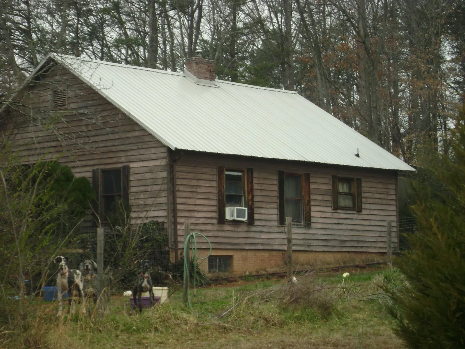 White metal roof on an old wood sided farmhouse, from a Metal Roof Installation job in Mc Clellanville